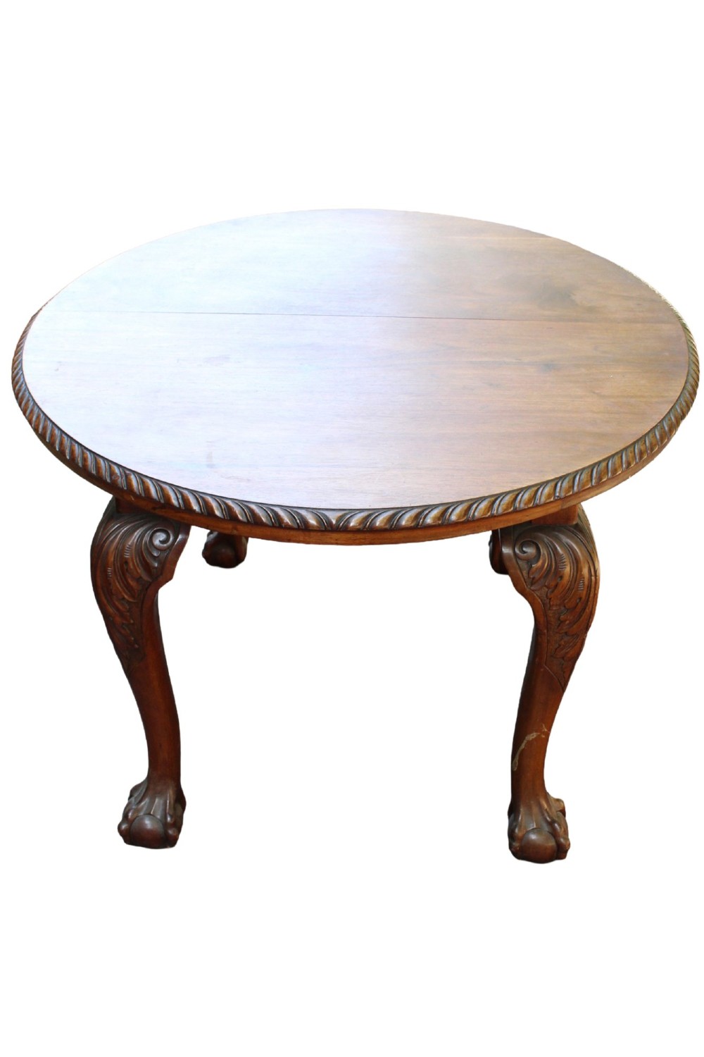 An antique Edwardian extending mahogany dining table featuring an oval top with gadrooned edges and carved cabriole legs terminating in ball-and-claw feet. View II