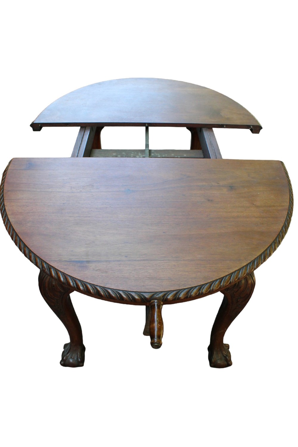 An antique Edwardian extending mahogany dining table featuring an oval top with gadrooned edges and carved cabriole legs terminating in ball-and-claw feet. View V