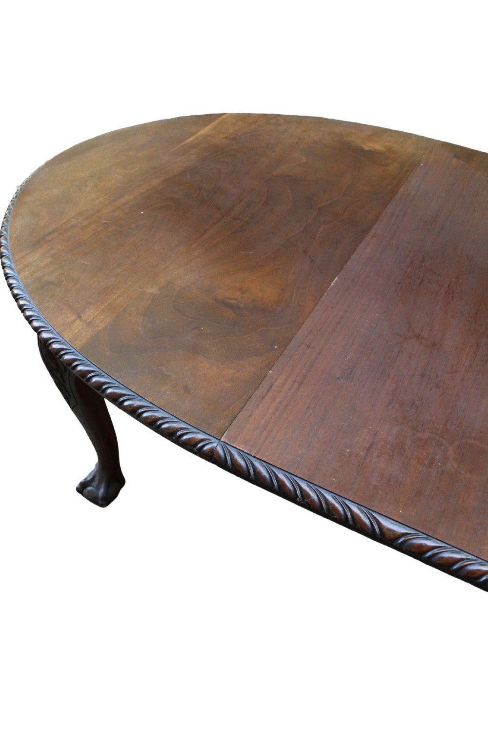 An antique Edwardian extending mahogany dining table featuring an oval top with gadrooned edges and carved cabriole legs terminating in ball-and-claw feet. View XI