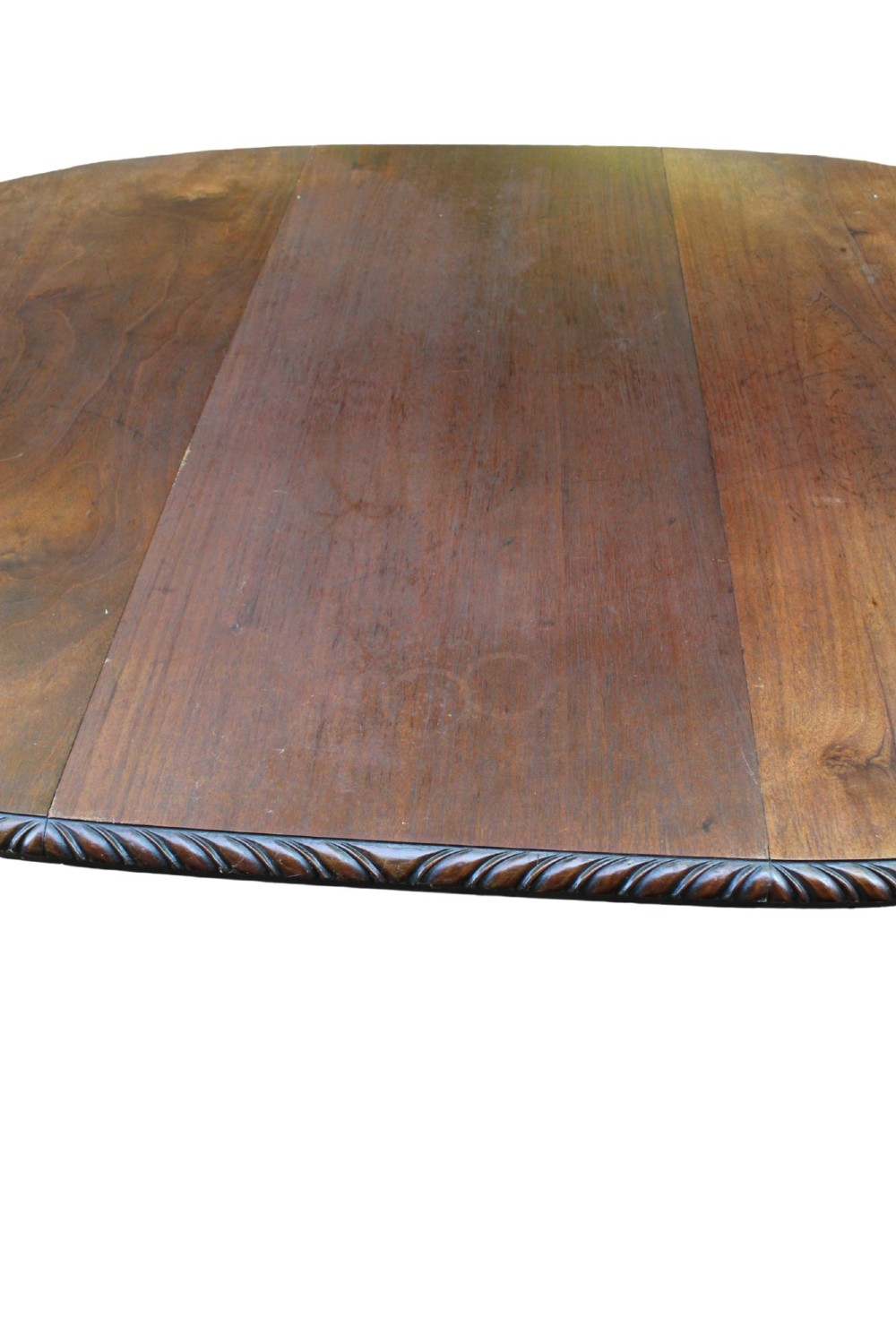 An antique Edwardian extending mahogany dining table featuring an oval top with gadrooned edges and carved cabriole legs terminating in ball-and-claw feet. View XII