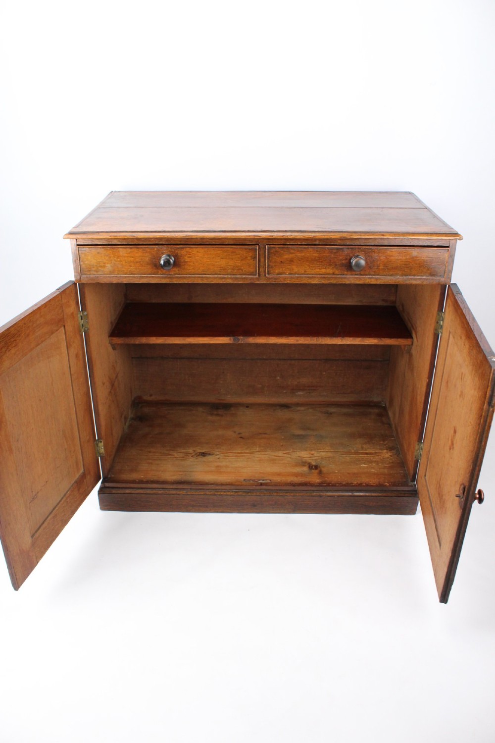 A low Georgian oak cupboard featuring two frieze drawers with turned wooden knobs above a pair of panelled cupboard doors. View II