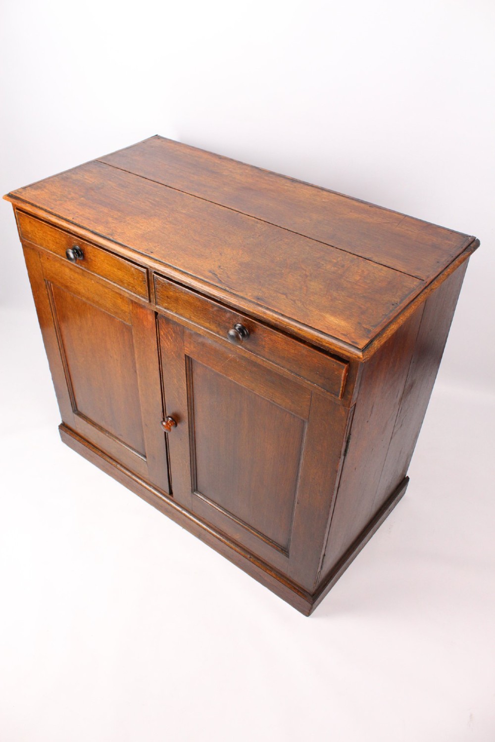 A low Georgian oak cupboard featuring two frieze drawers with turned wooden knobs above a pair of panelled cupboard doors. View III
