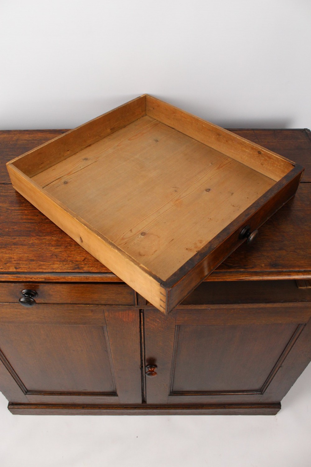 A low Georgian oak cupboard featuring two frieze drawers with turned wooden knobs above a pair of panelled cupboard doors. View VI
