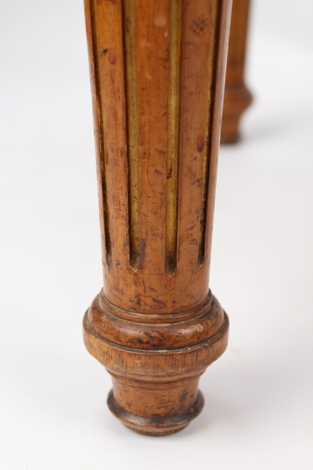 A square Victorian oak dressing stool featuring fluted turned legs with gilt accents and a cream fabric seat decorated with green leaf motifs. View VIII