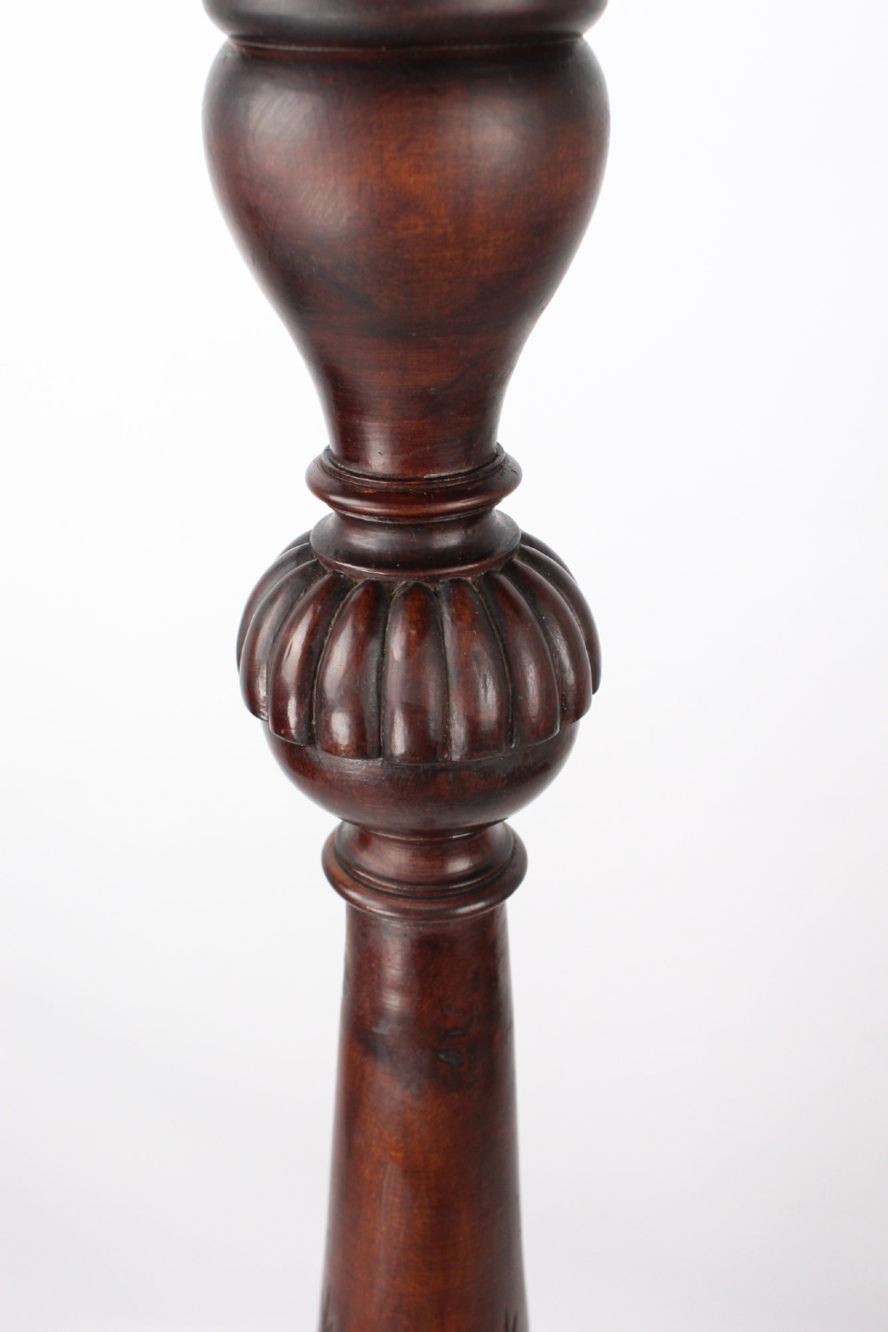 A tall Edwardian mahogany plant stand with a circular top, carved acanthus leaf column, and a tripod base. View IV