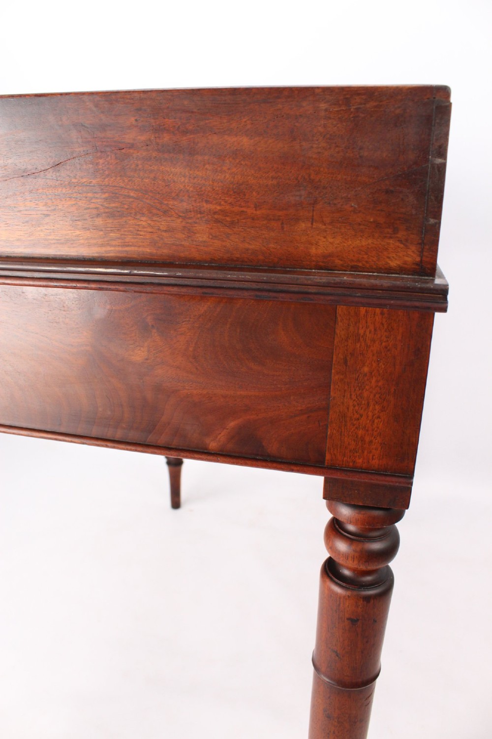 A Victorian mahogany writing table featuring a low gallery back top, two frieze drawers with decorative handles, and four turned legs. View XI