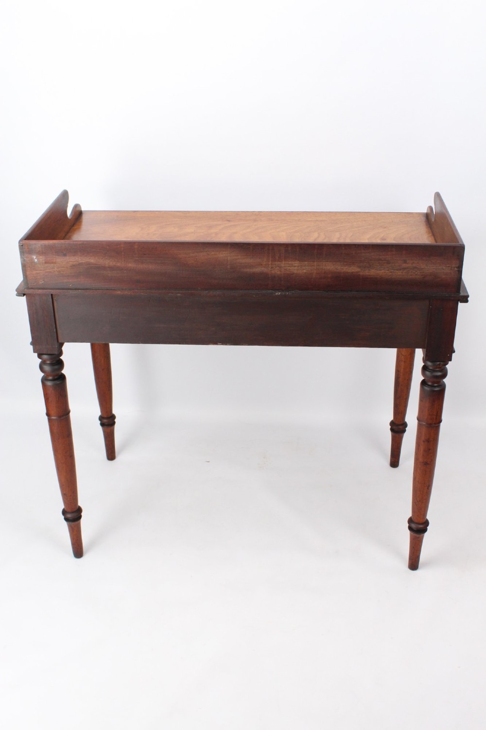 A Victorian mahogany writing table featuring a low gallery back top, two frieze drawers with decorative handles, and four turned legs. View XII