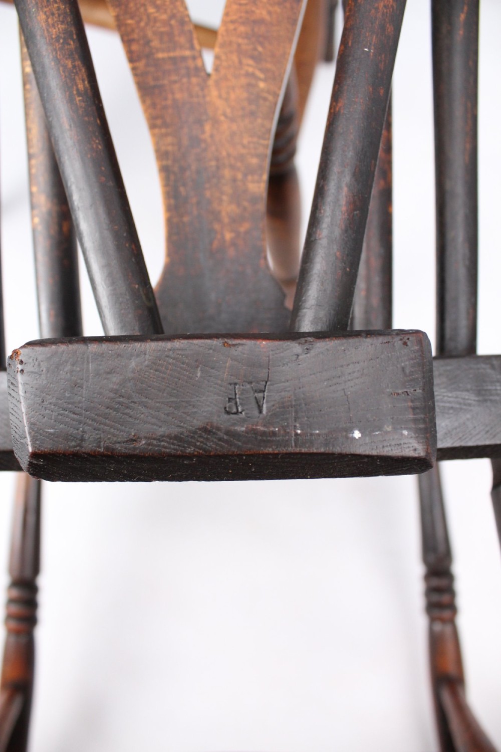 A near pair of antique dark timber Windsor kitchen chairs featuring pierced wheelback splats, contoured saddle seats, and turned legs. View VI