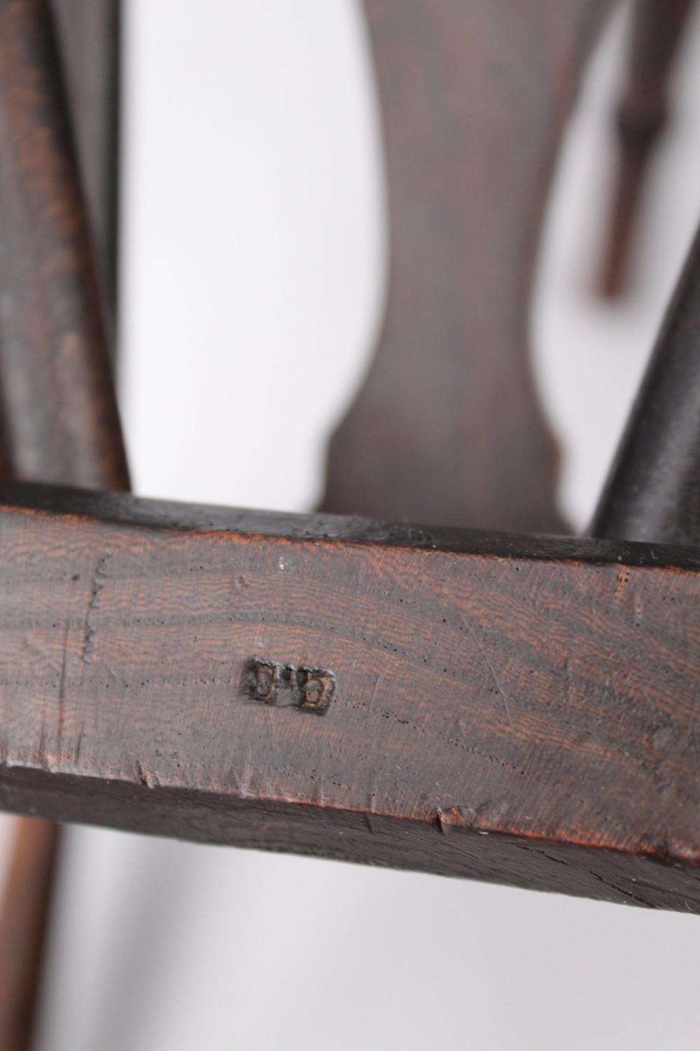A near pair of antique dark timber Windsor kitchen chairs featuring pierced wheelback splats, contoured saddle seats, and turned legs. View VII