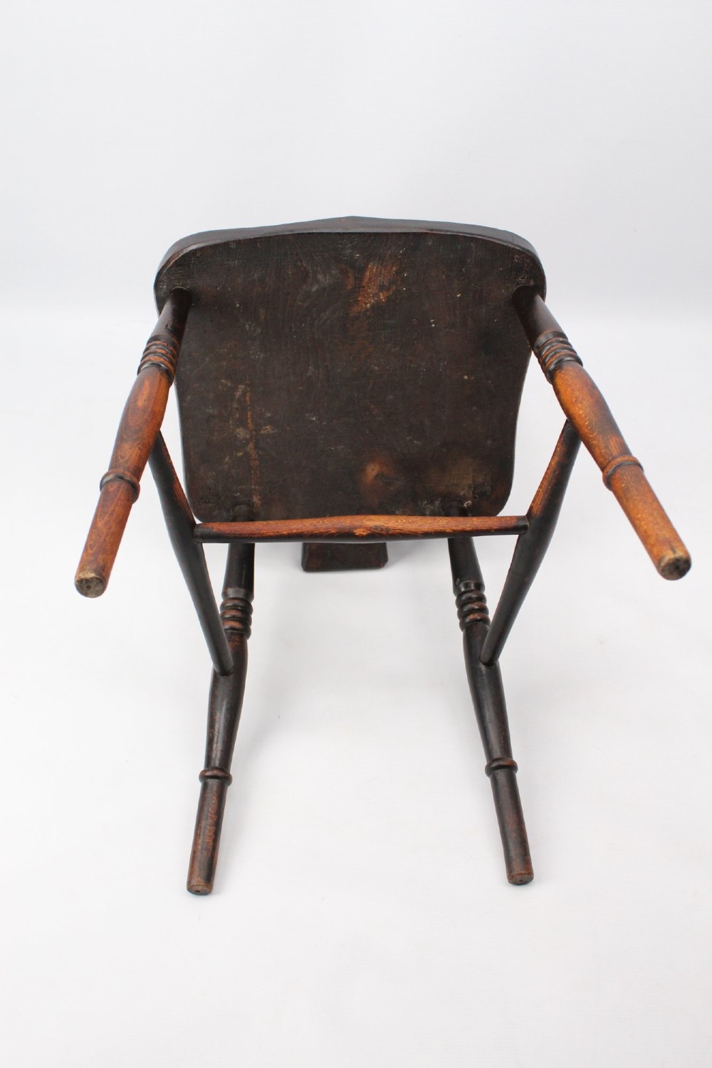 A near pair of antique dark timber Windsor kitchen chairs featuring pierced wheelback splats, contoured saddle seats, and turned legs. View XII