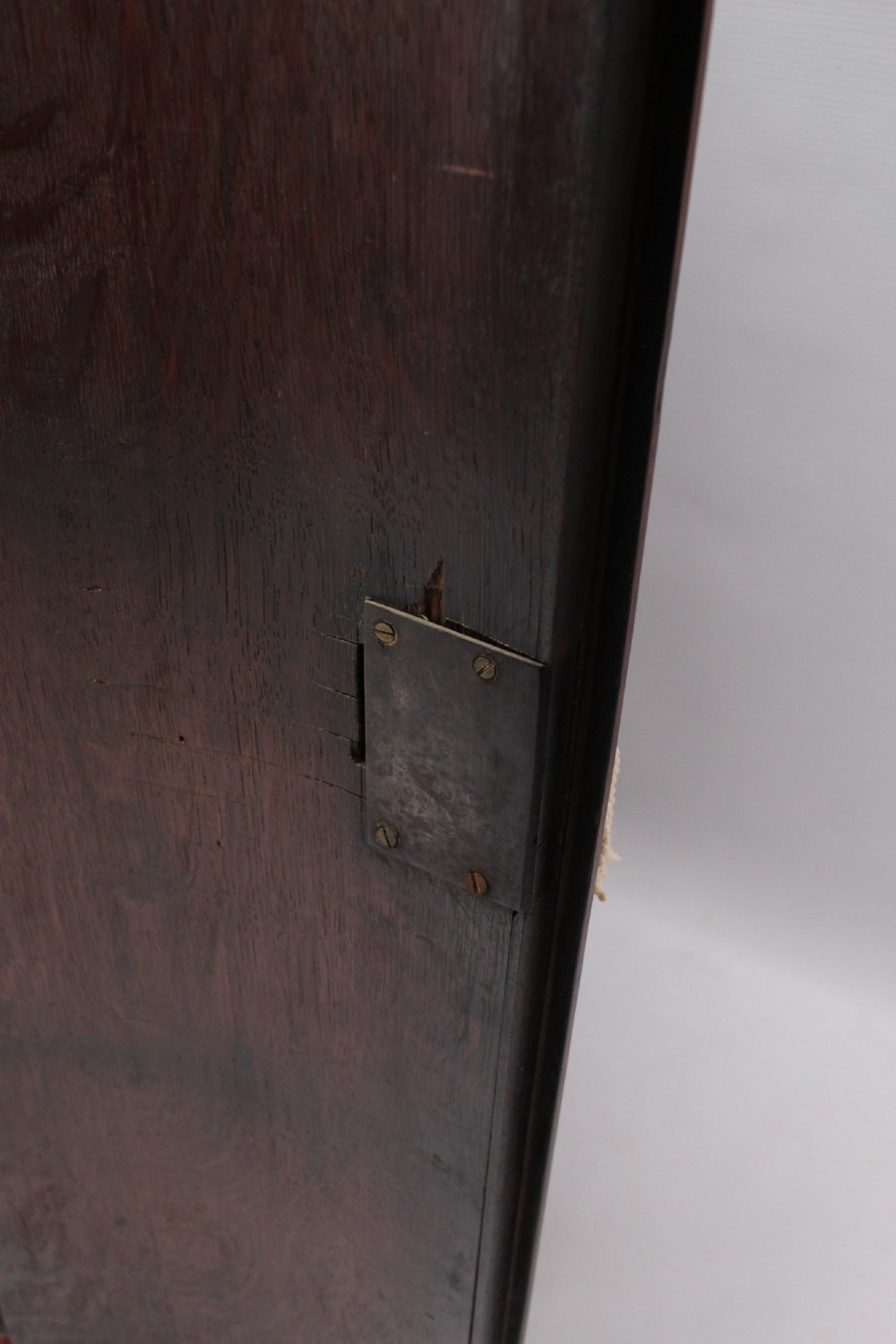 An 18th-century Georgian oak corner cupboard featuring a curved bow front, brass H-hinges, keyhole escutcheon plates, and mahogany crossbanding. View V