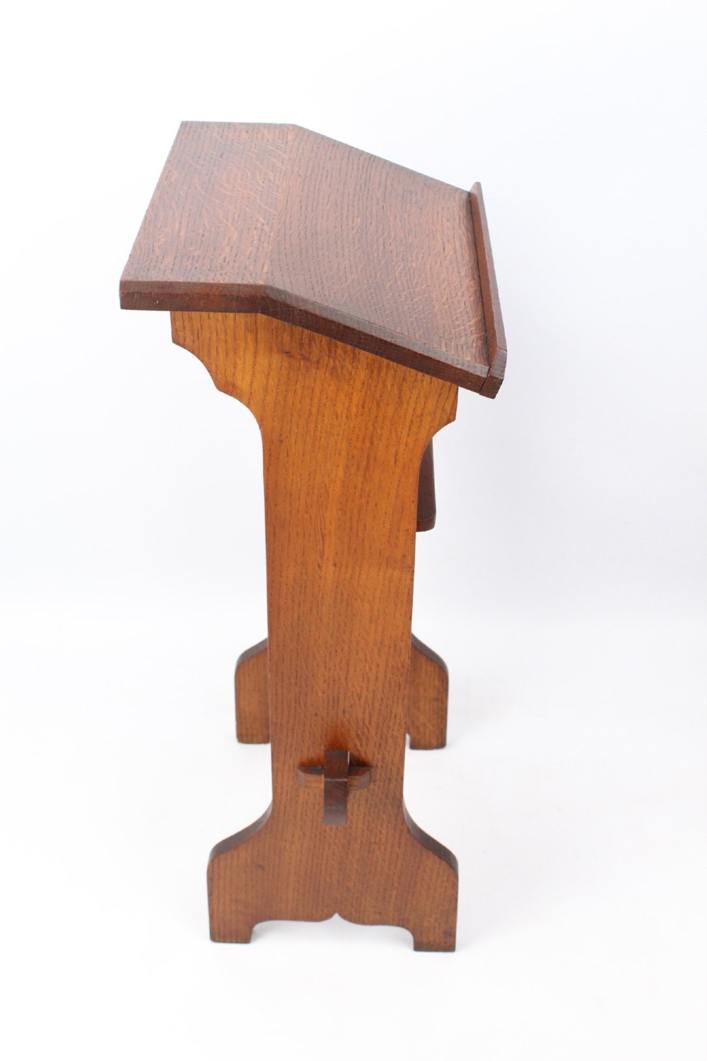 An Edwardian Arts and Crafts solid oak lectern featuring an angled reading top, an open middle shelf, and visible wedge tenon joinery. View IV