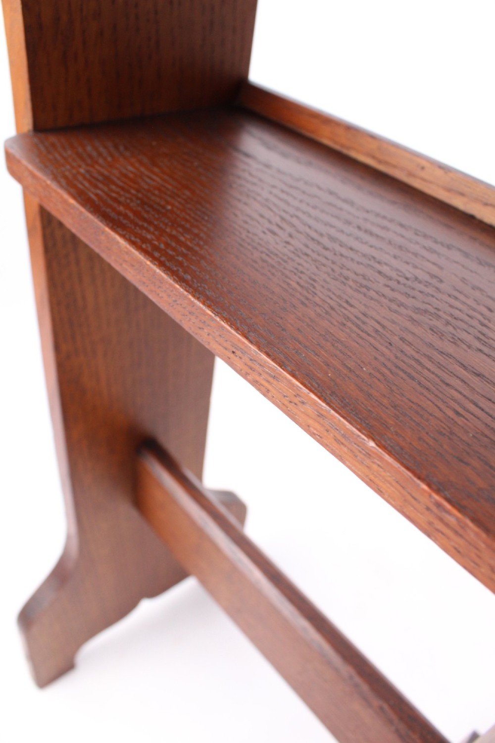 An Edwardian Arts and Crafts solid oak lectern featuring an angled reading top, an open middle shelf, and visible wedge tenon joinery. View VI