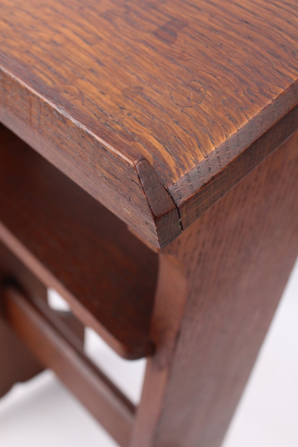 An Edwardian Arts and Crafts solid oak lectern featuring an angled reading top, an open middle shelf, and visible wedge tenon joinery. View VIII