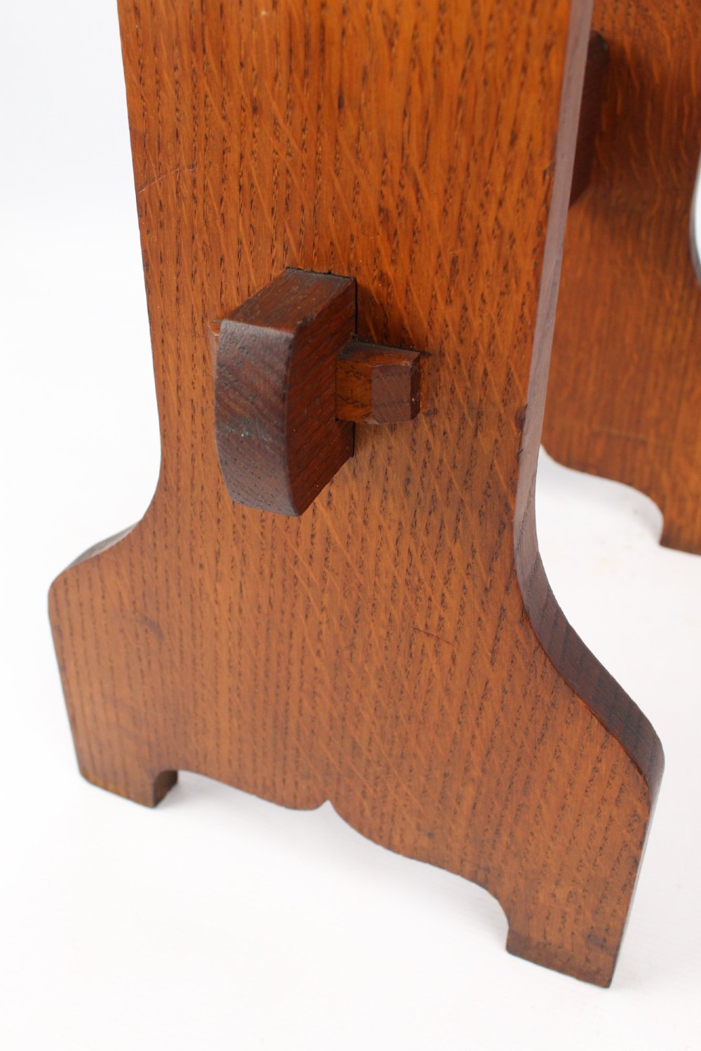 An Edwardian Arts and Crafts solid oak lectern featuring an angled reading top, an open middle shelf, and visible wedge tenon joinery. View X