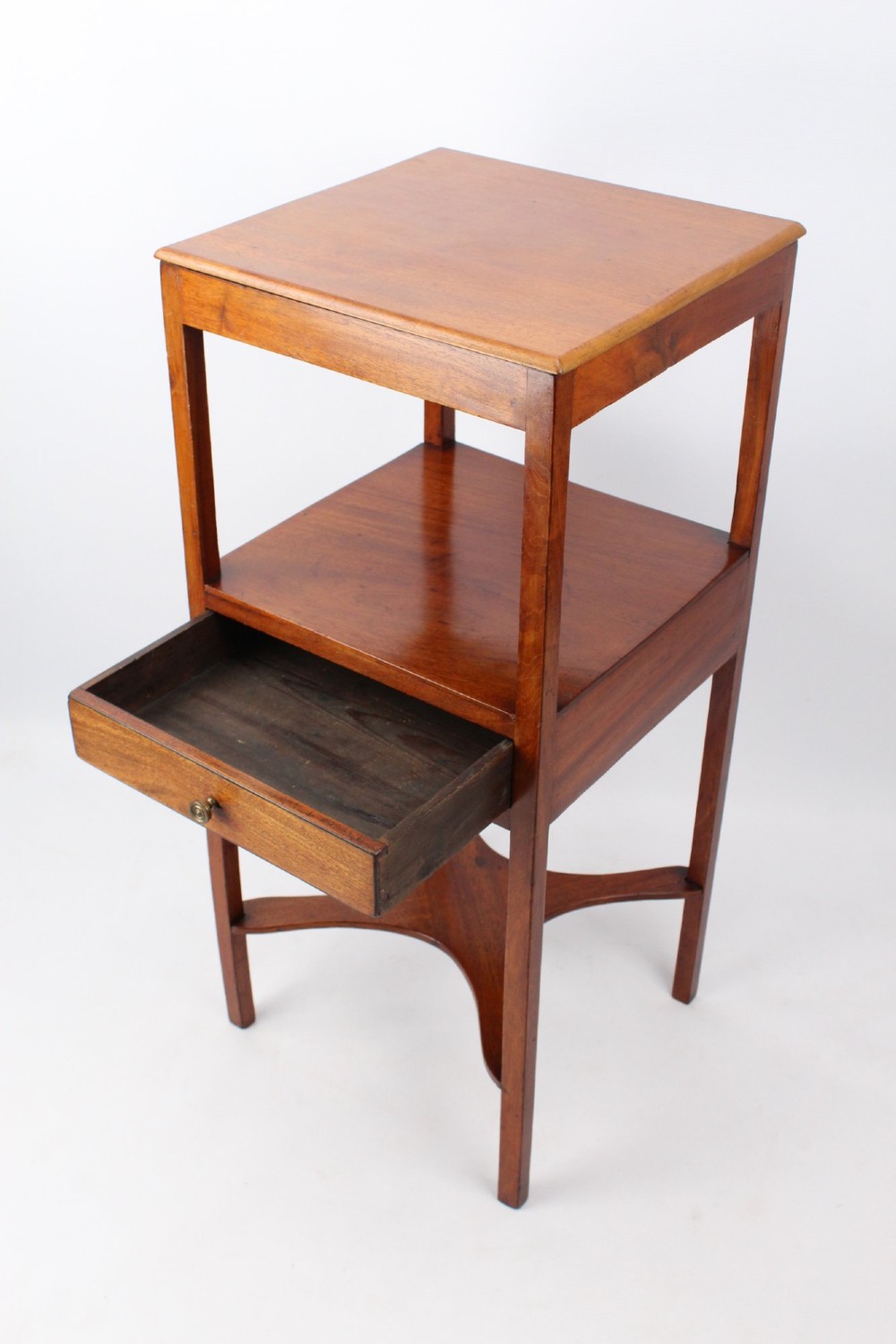A two-tier Georgian mahogany bedside table with a single drawer, square top, and curved X-form stretcher. View II