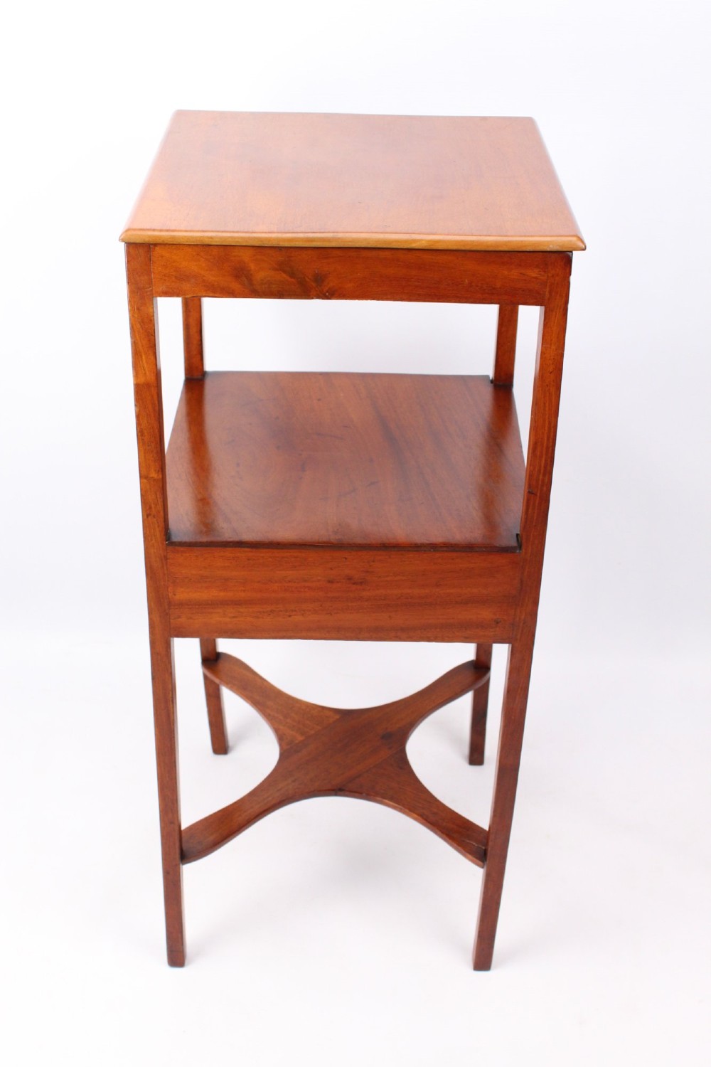 A two-tier Georgian mahogany bedside table with a single drawer, square top, and curved X-form stretcher. View IV