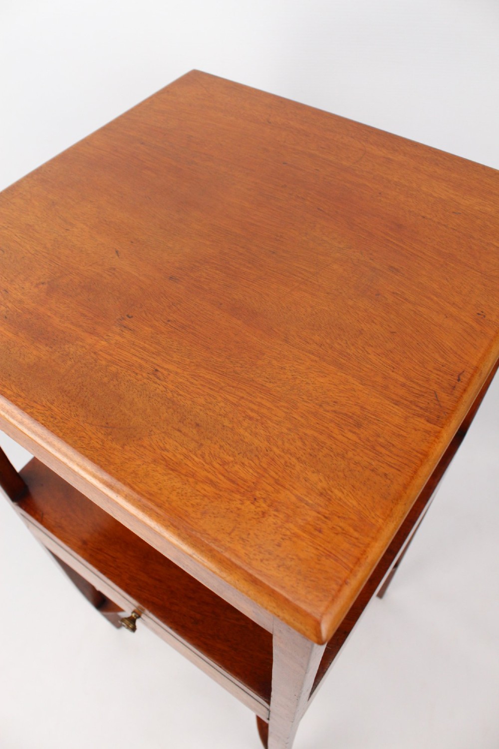 A two-tier Georgian mahogany bedside table with a single drawer, square top, and curved X-form stretcher. View XII