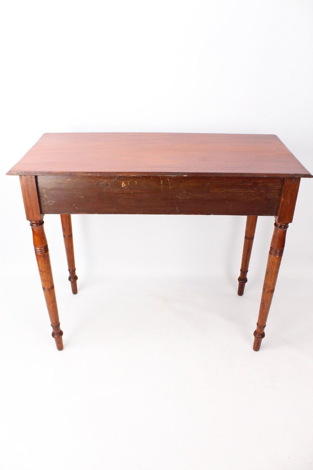A Victorian mahogany writing table featuring a long frieze drawer with two turned wooden knobs, elevated on four ring-turned tapered legs. View VII