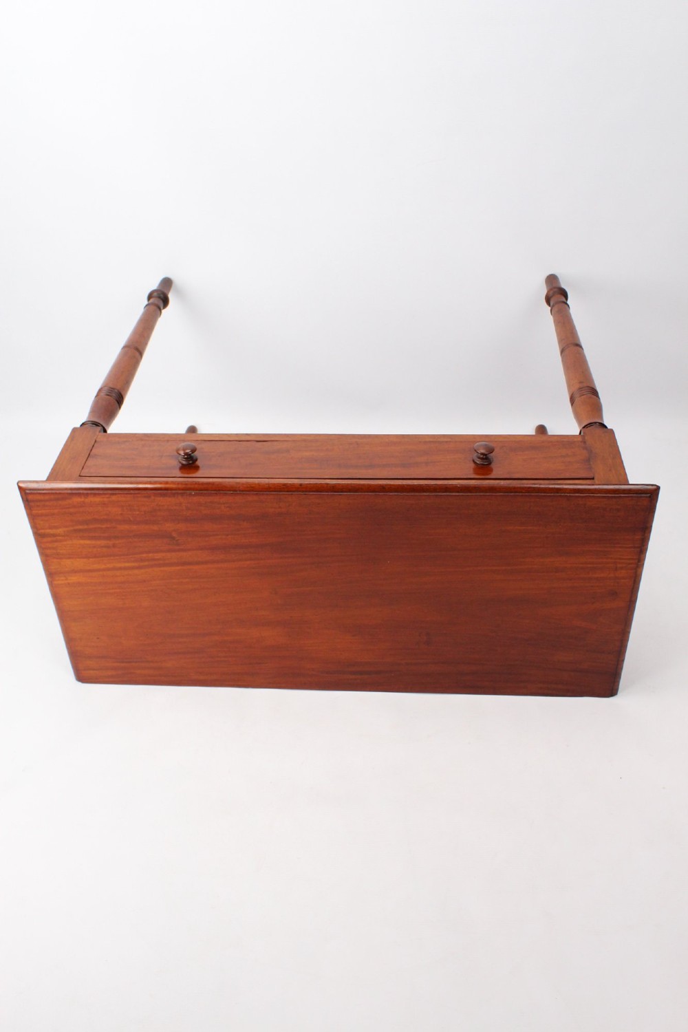 A Victorian mahogany writing table featuring a long frieze drawer with two turned wooden knobs, elevated on four ring-turned tapered legs. View VIII