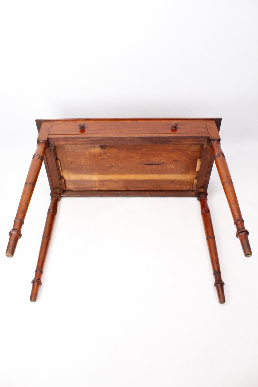A Victorian mahogany writing table featuring a long frieze drawer with two turned wooden knobs, elevated on four ring-turned tapered legs. View IX