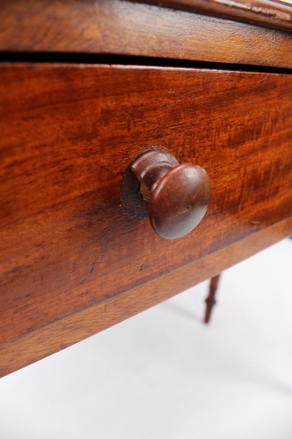 A Victorian mahogany writing table featuring a long frieze drawer with two turned wooden knobs, elevated on four ring-turned tapered legs. View XIII