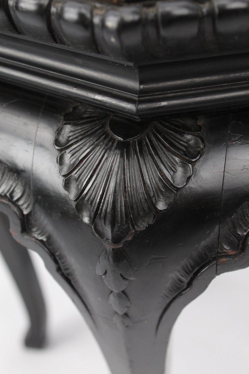 An antique ebonised hexagonal wooden coffee table featuring carved shell details along the apron and cabriole legs against a white background. View III