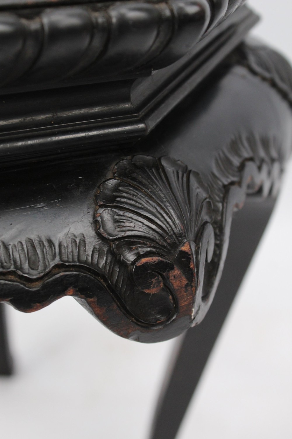 An antique ebonised hexagonal wooden coffee table featuring carved shell details along the apron and cabriole legs against a white background. View IV