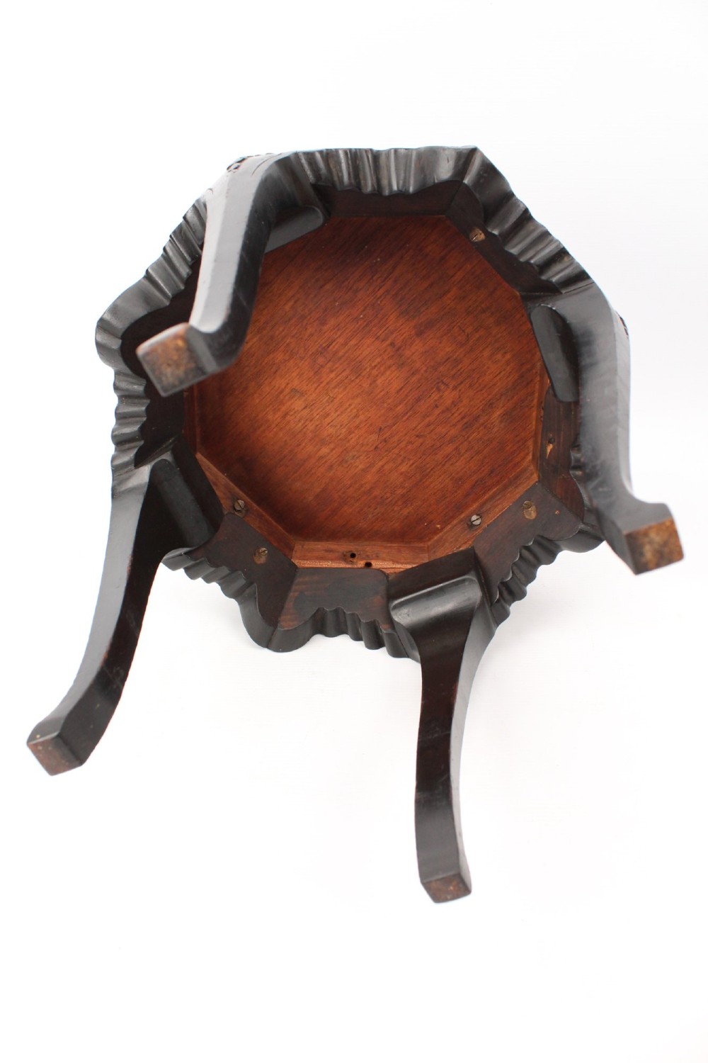 An antique ebonised hexagonal wooden coffee table featuring carved shell details along the apron and cabriole legs against a white background. View X
