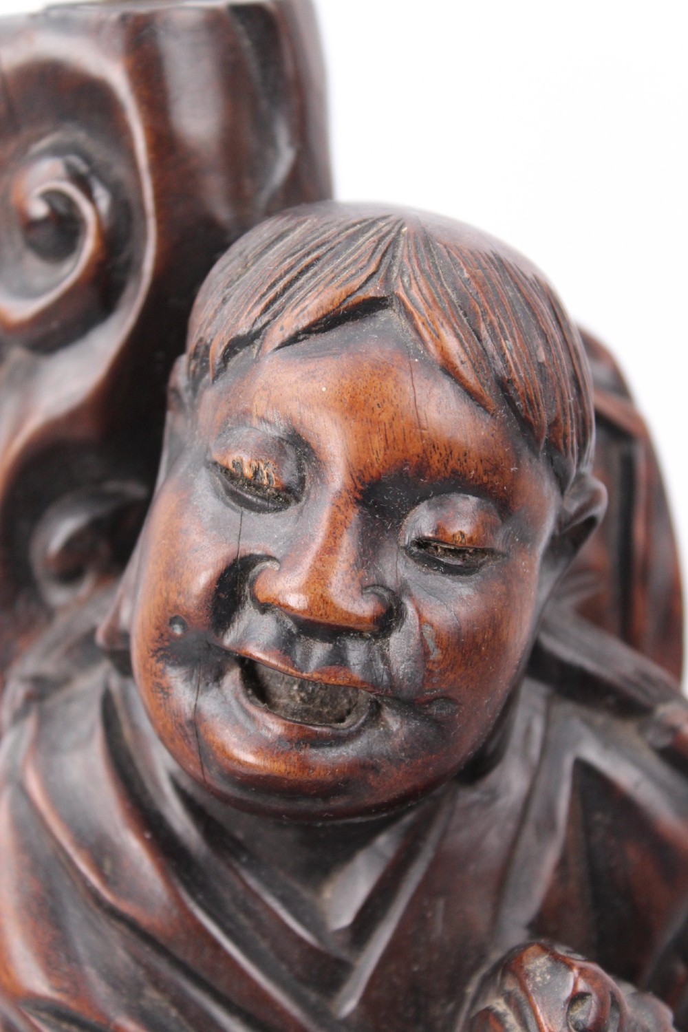 A hand-carved dark wood figure of the Daoist Immortal Liu Hai holding a three-legged toad, set upon a carved rockwork base with a brass lamp fitting at the top. View IV