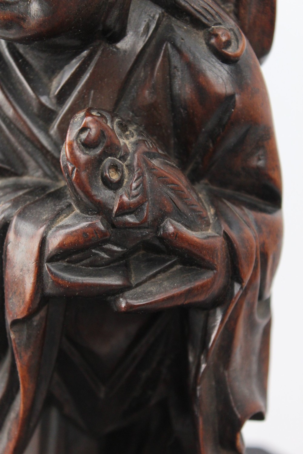 A hand-carved dark wood figure of the Daoist Immortal Liu Hai holding a three-legged toad, set upon a carved rockwork base with a brass lamp fitting at the top. View V