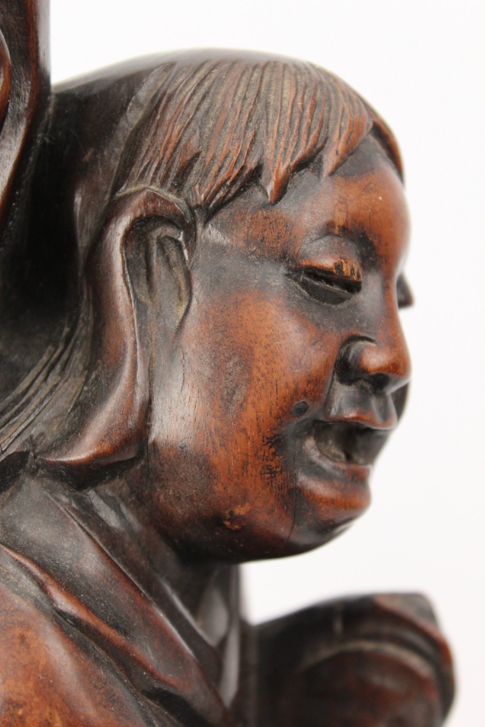 A hand-carved dark wood figure of the Daoist Immortal Liu Hai holding a three-legged toad, set upon a carved rockwork base with a brass lamp fitting at the top. View IX
