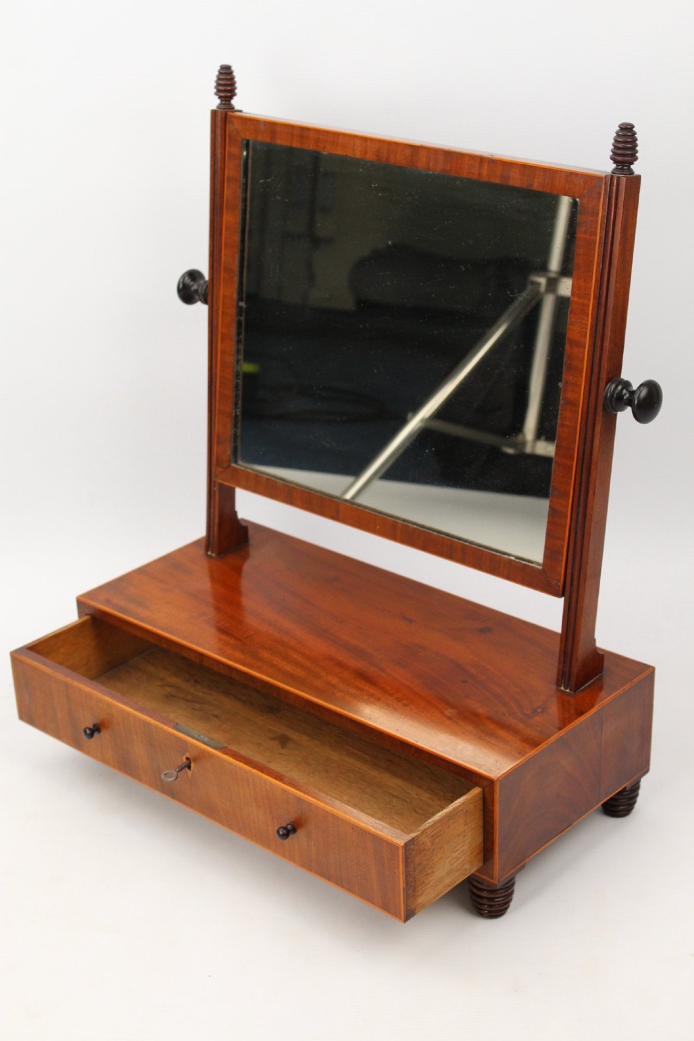 An antique Regency mahogany toilet mirror featuring an adjustable rectangular mirror set between turned upright posts above a single drawer base. View V