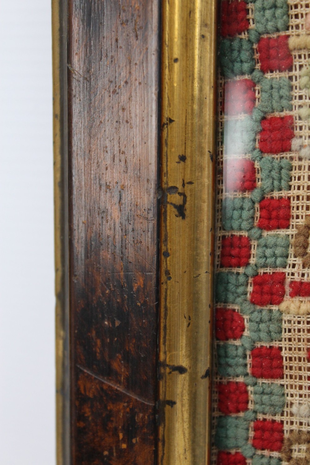 A framed 1875 Victorian needlework sampler featuring rows of embroidered alphabets, geometric borders, and text reading Mary J Garbutt Aged 12 Years inside a wooden frame. View VIII
