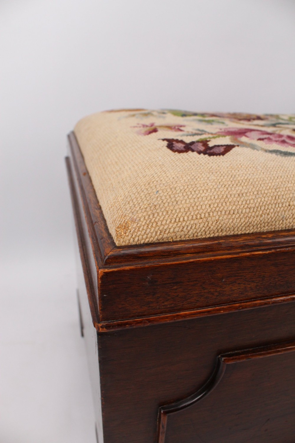 A low rectangular dark mahogany storage ottoman featuring a beige upholstered top with floral needlework embroidery. View XI