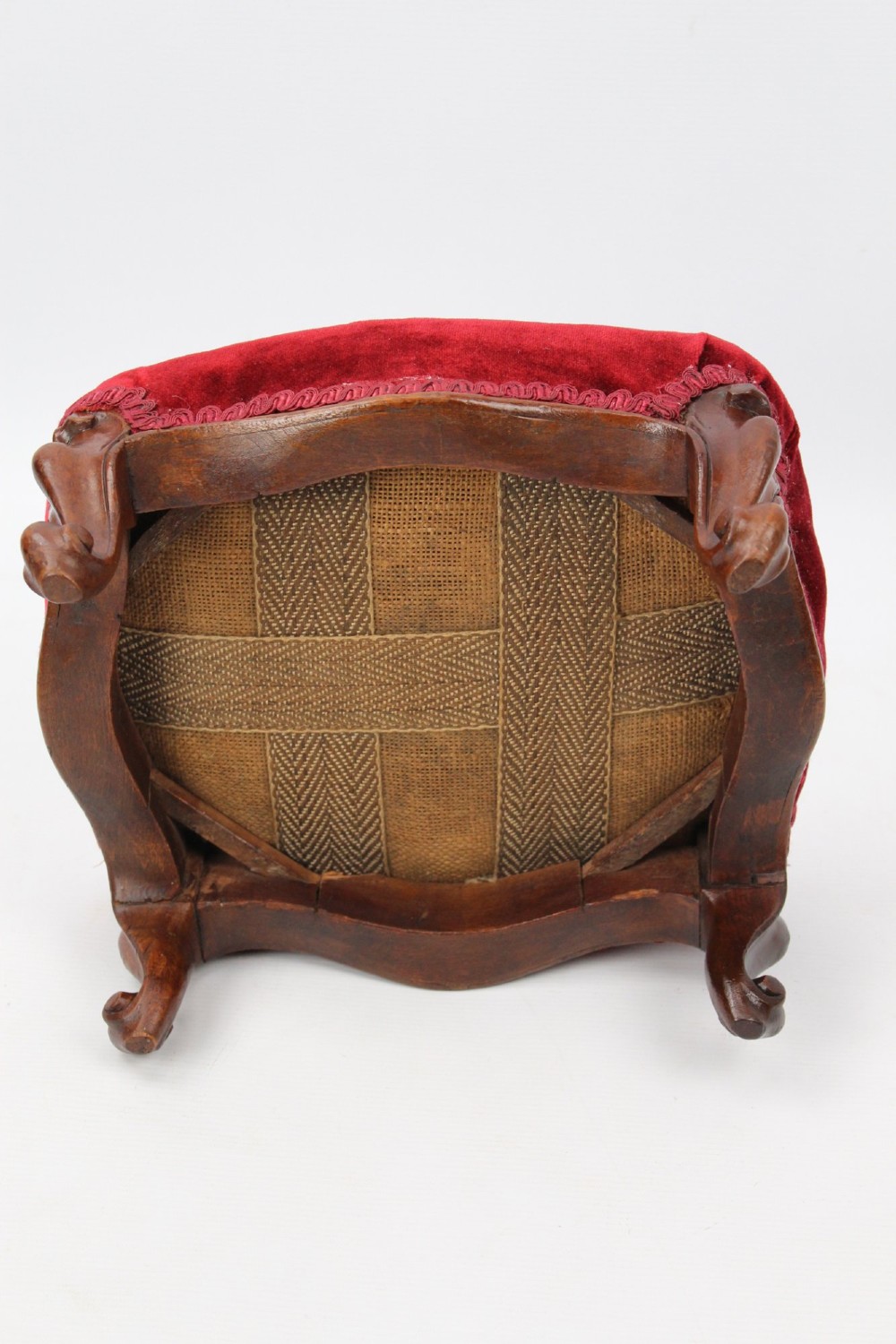 A pair of small Victorian footstools featuring crimson red velvet upholstery and carved walnut cabriole feet. View VIII