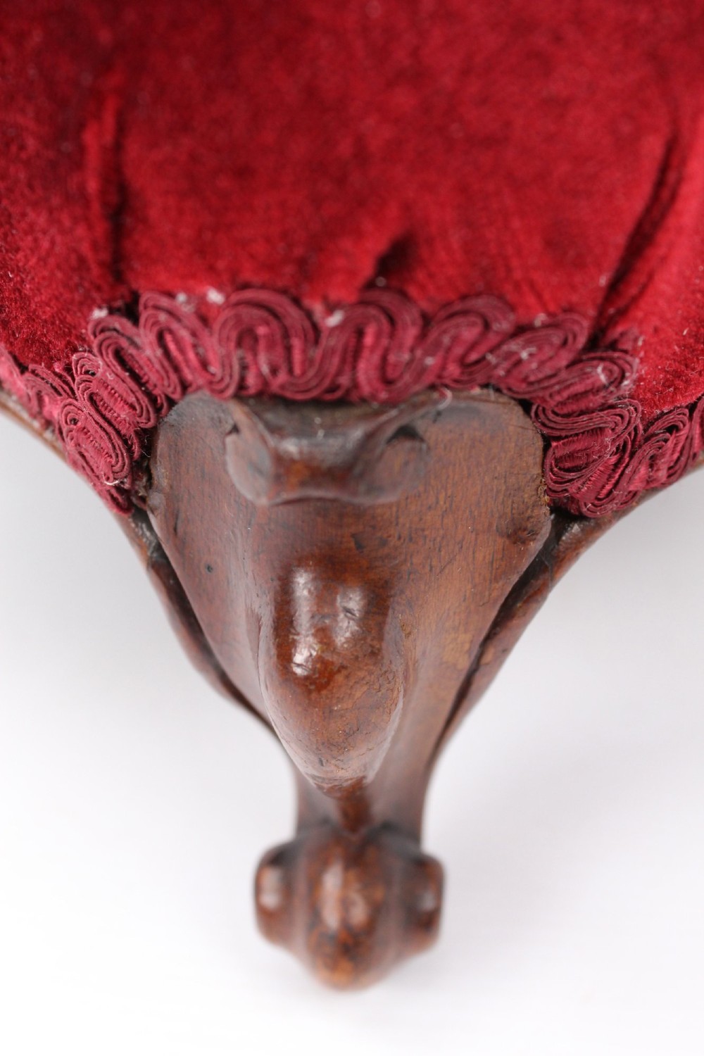 A pair of small Victorian footstools featuring crimson red velvet upholstery and carved walnut cabriole feet. View XI