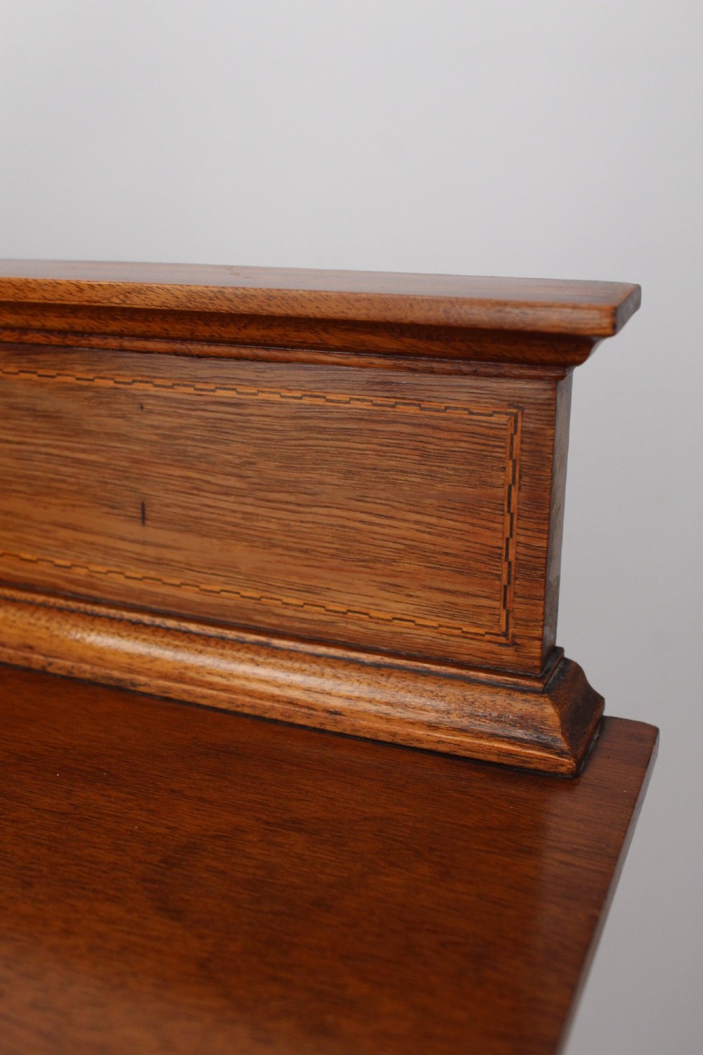 An Edwardian mahogany music cabinet featuring six shallow drawers with brass handles, set on slender square tapered legs with a raised gallery back. View XI
