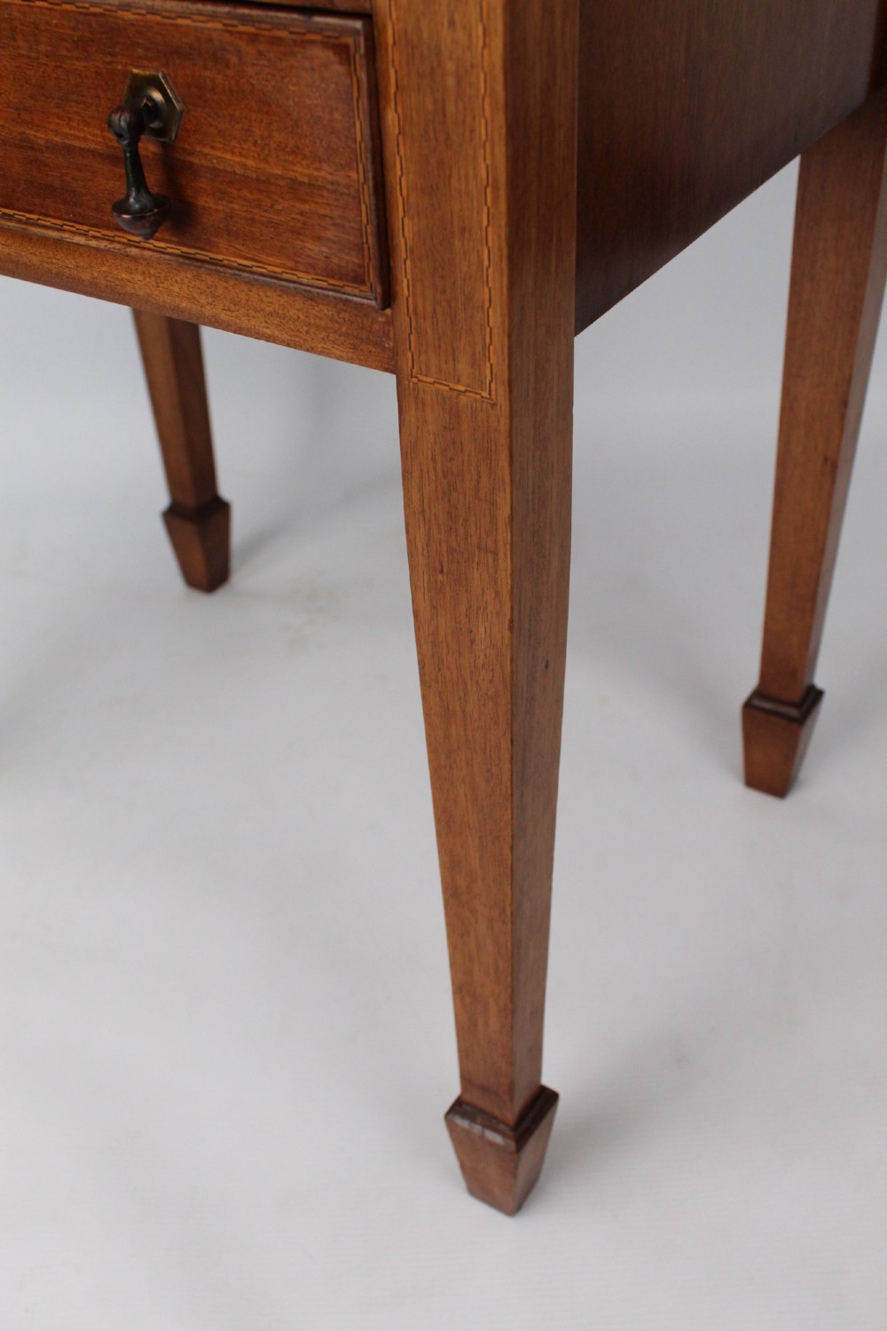 An Edwardian mahogany music cabinet featuring six shallow drawers with brass handles, set on slender square tapered legs with a raised gallery back. View XII