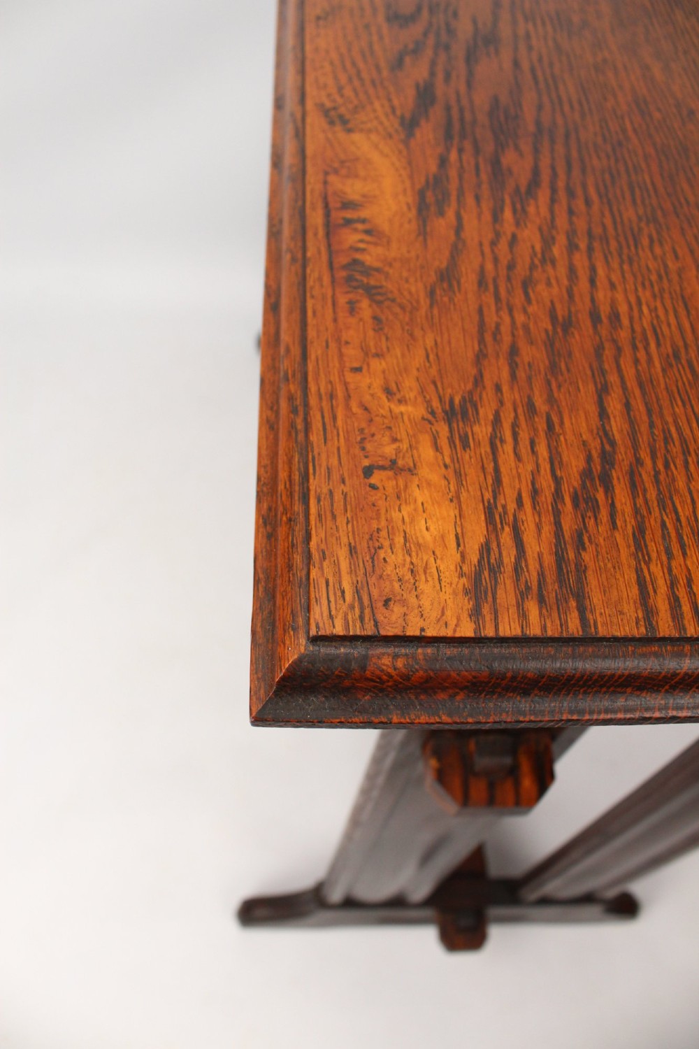 An Edwardian Arts and Crafts medium brown oak side table featuring double upright supports, exposed joint details, and a low stretcher. View VIII
