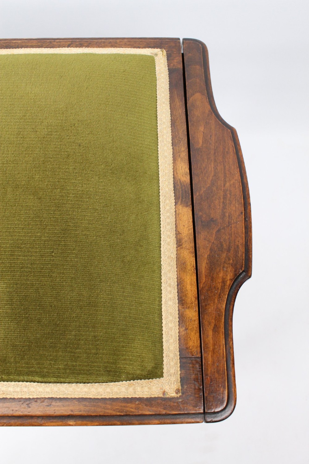 An Edwardian wooden duet piano stool featuring an olive green velvet upholstered seat and slender tapered legs. View XII