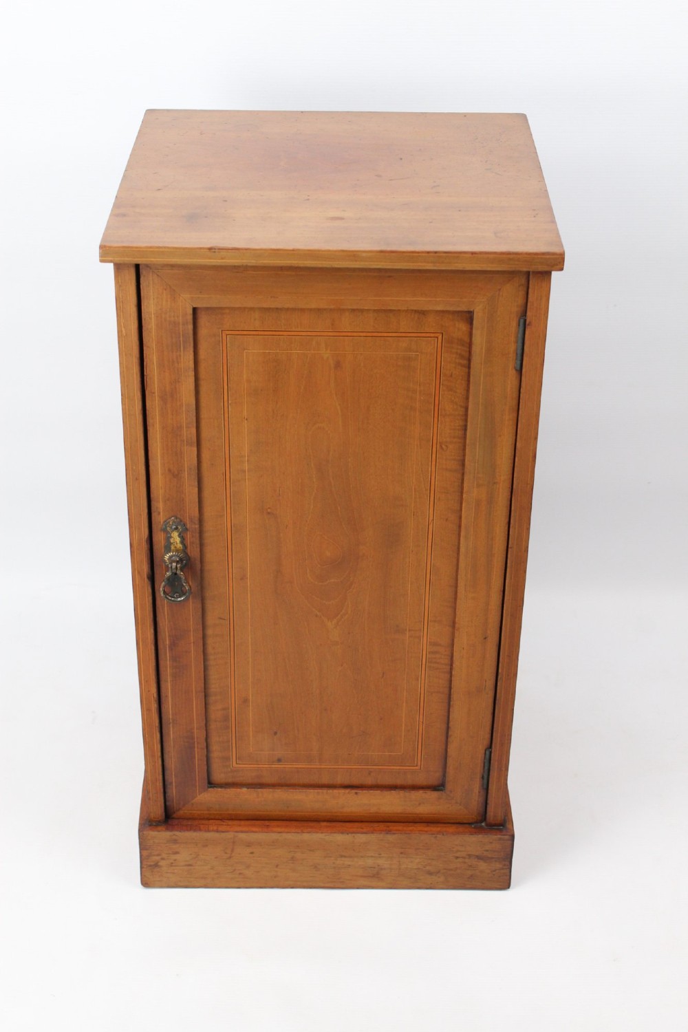 A small Edwardian mahogany bedside cabinet featuring fine boxwood string inlay on the single cupboard door and a brass drop handle.