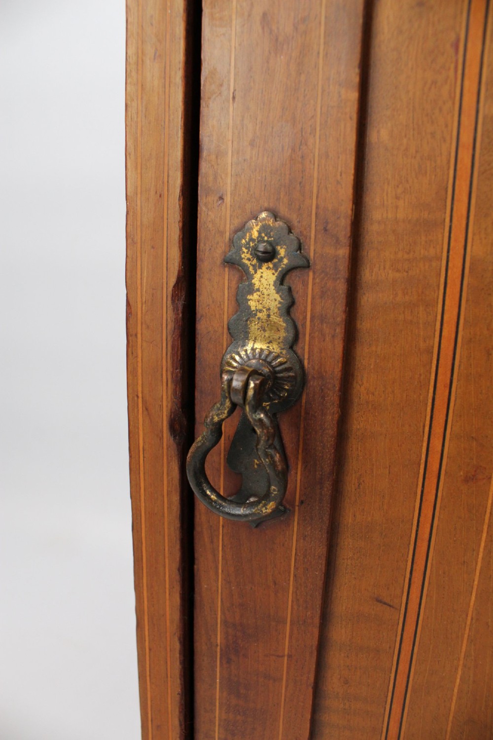 A small Edwardian mahogany bedside cabinet featuring fine boxwood string inlay on the single cupboard door and a brass drop handle. View X