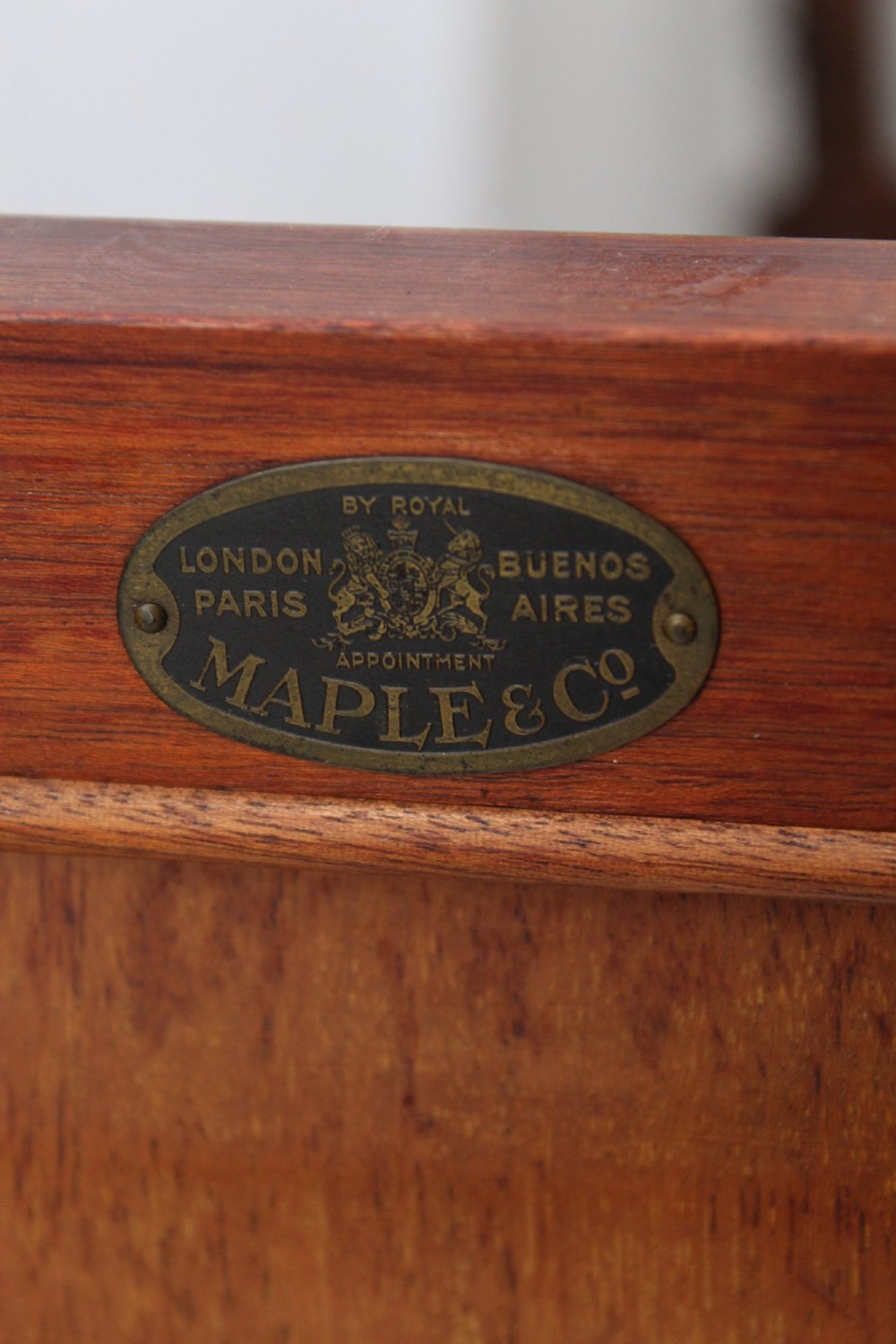 An Edwardian burr walnut bedside cabinet featuring a small gallery top, crossbanded inlaid door panel, drop brass handle, and square tapered legs. View VII