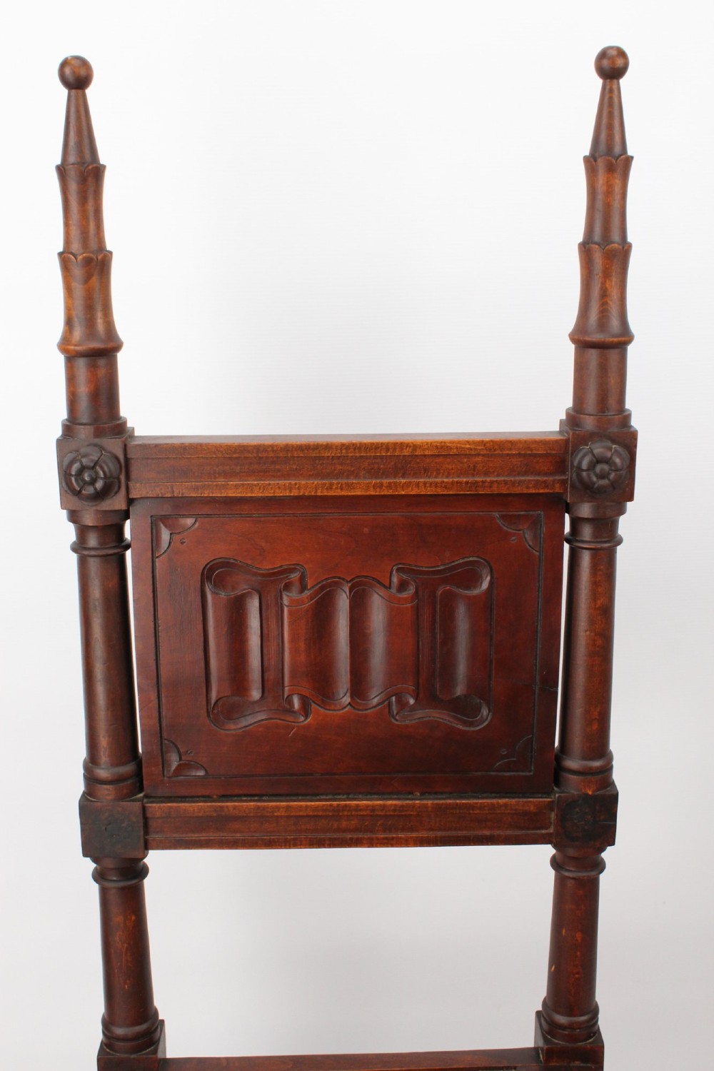 A Victorian Gothic Revival side chair made of dark oak with turned finials, a carved rectangular back panel, pointed arch aprons, and a woven rush seat. View VII
