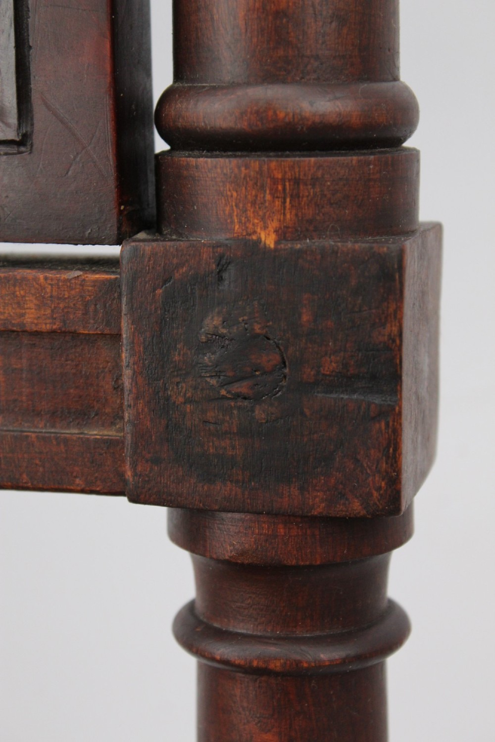 A Victorian Gothic Revival side chair made of dark oak with turned finials, a carved rectangular back panel, pointed arch aprons, and a woven rush seat. View XII