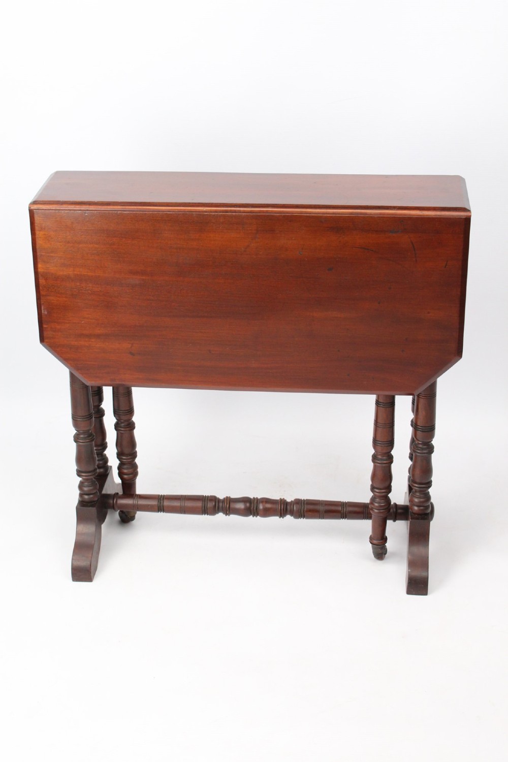 A small Victorian mahogany Sutherland table shown folded with two drop leaves, slender turned spindle legs, and a low stretcher base. View II