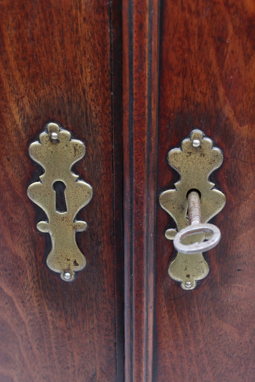 A Georgian mahogany bow front corner cupboard with twin curved doors and decorative brass hinges and keyhole escutcheons. View XIII