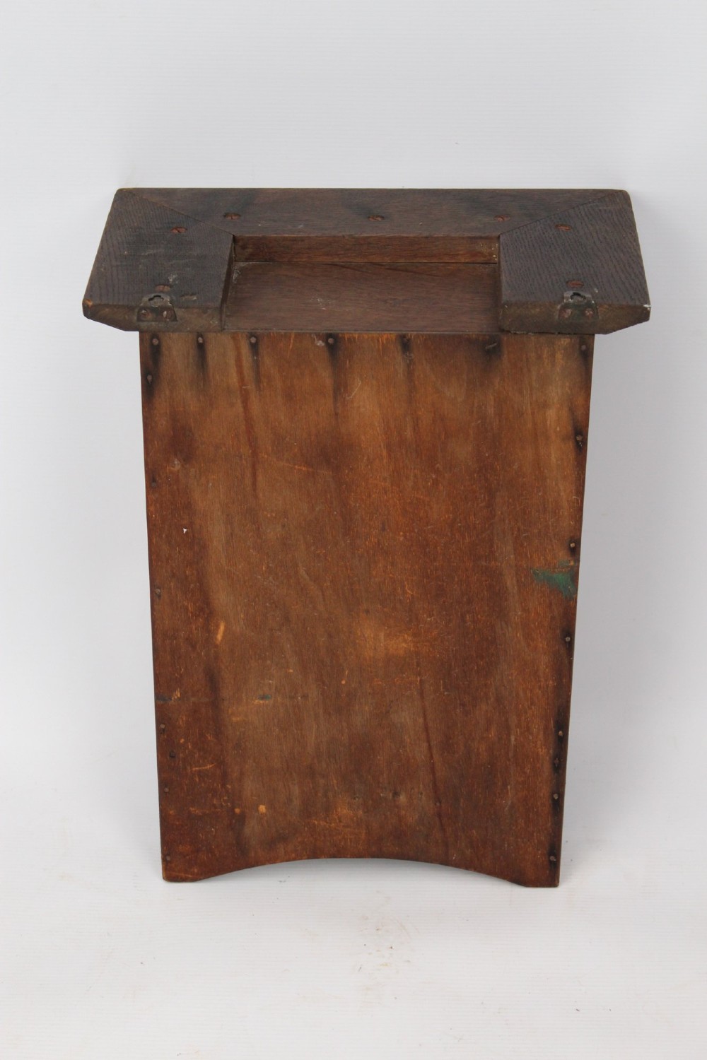 A small Edwardian Arts and Crafts oak wall cabinet featuring a single door decorated with a carved stylized floral panel and small brass hinges. View X