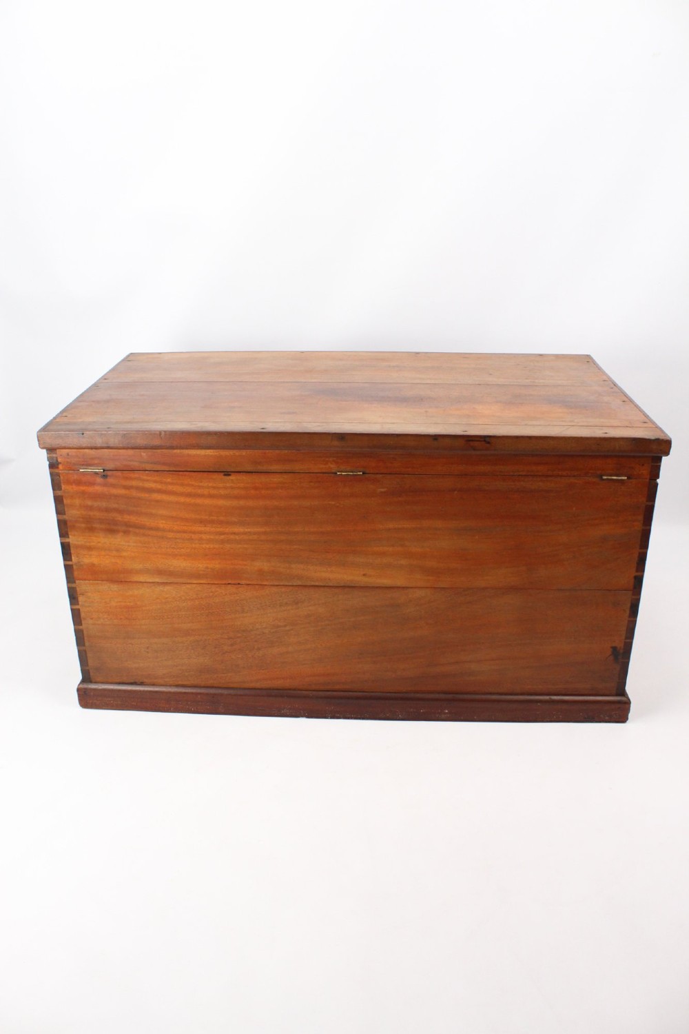 A rectangular Victorian mahogany storage chest featuring exposed dovetail corner joints, a flat hinged lid, and a central brass handle. View V